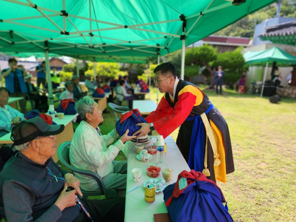 ▲ 장수 어르신에게 선물을 전달하고 있다.