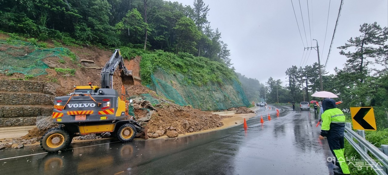 ▲집중호우로 인해 돌산 대율마을 입구의 절개사면 토사가 도로로 쏟아져 내려 중장비를 동원 복구하고 있다. ⓒ독자 제공