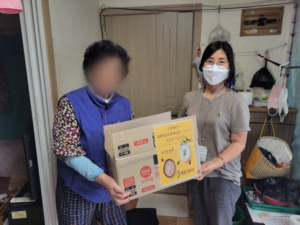 ▲ 지원 대상자와 영양죽 전달 사진을 촬영하고 있다.