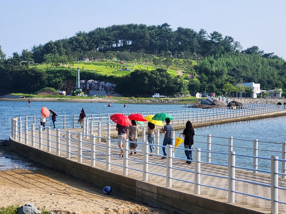 ▲ 장도 입구에 배치된 양산을 쓰고 있다.