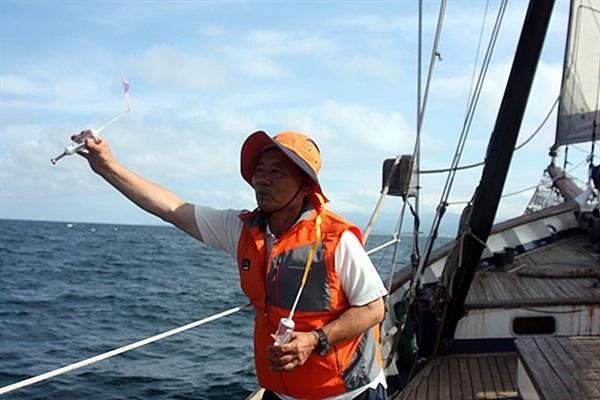 ▲ 쿠로시오해류의 이동을 검증하기 위해 코리아나호에서 바다를 향해 해류병을 던지는 이효웅씨 모습 ⓒ 오문수
