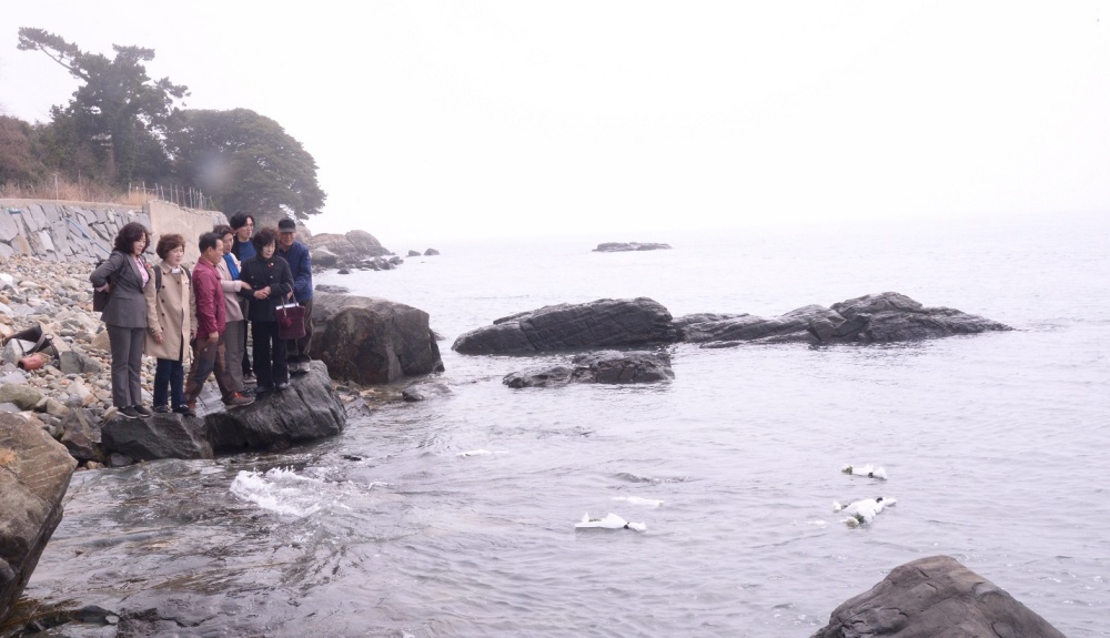 ▲두룩여 해상이 보이는 바닷가에서 헌화하고 있다.  자료사진