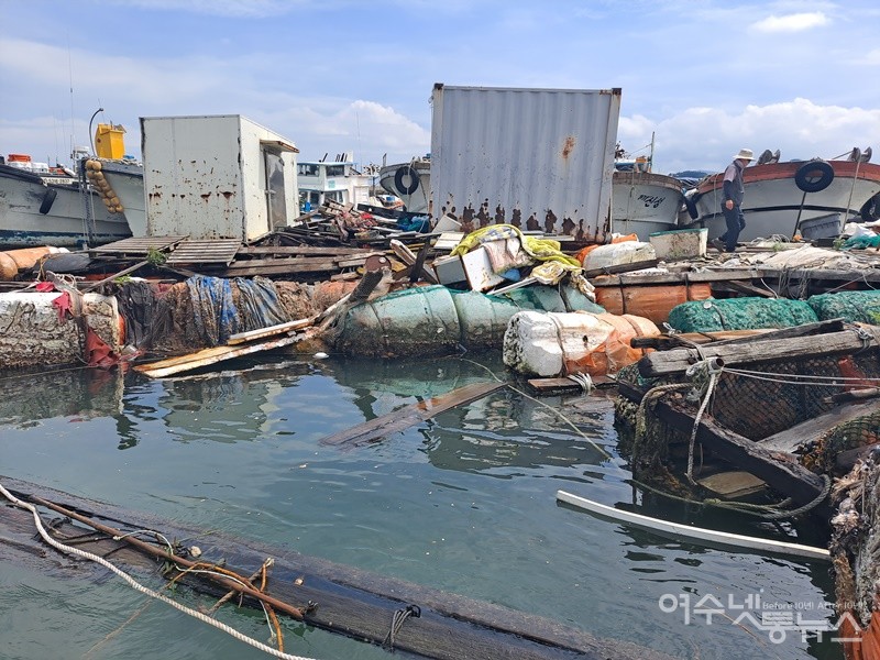 ▲여수 국동항 파제제 안쪽 폐바지선, 해양쓰레기가 널브러진 현장을 작업자가 위태롭게 걸어가고 있다. ⓒ조찬현