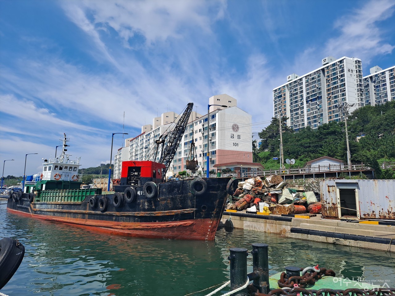 ▲여수 국동항에 방치된 폐바지선과 해양쓰레기를 폐기물 수거선에 실어 신월동 관공선부두로 옮기고 있다. ⓒ조찬현