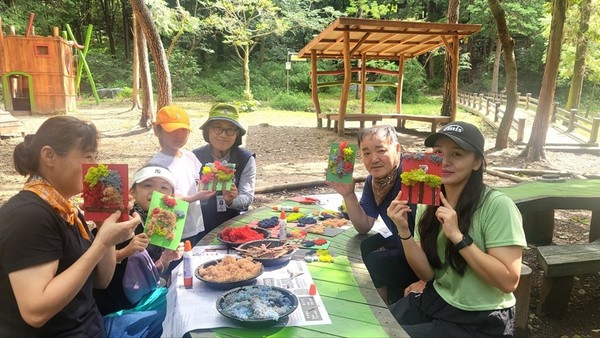 ▲ 5명의 한 가족이, 만든 ‘스칸디아모스 액자’를 들고 있다. 왼쪽 끝에 최윤정 해설사가 사진을 같이 찍고 있다.  ⓒ최윤정.