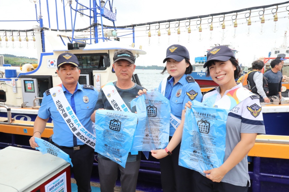 ▲낚시어선 종사자에게 해양쓰레기 되기져오기 캠페인 홍보와 함께 쓰레기 종량제봉투 배부하고 있다.