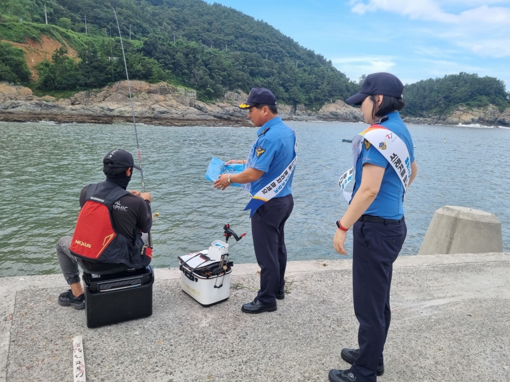 ▲ 낚시객에게 쓰레기 무단투기 홍보와 함께 종량제봉투 배부하는 해경
