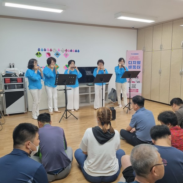 ▲  여러 장르에 곡을 연주하는  '사랑의 하모니' 와  햇터교실 친구들이 음률 감상을 하고있다. ⓒ 김연우