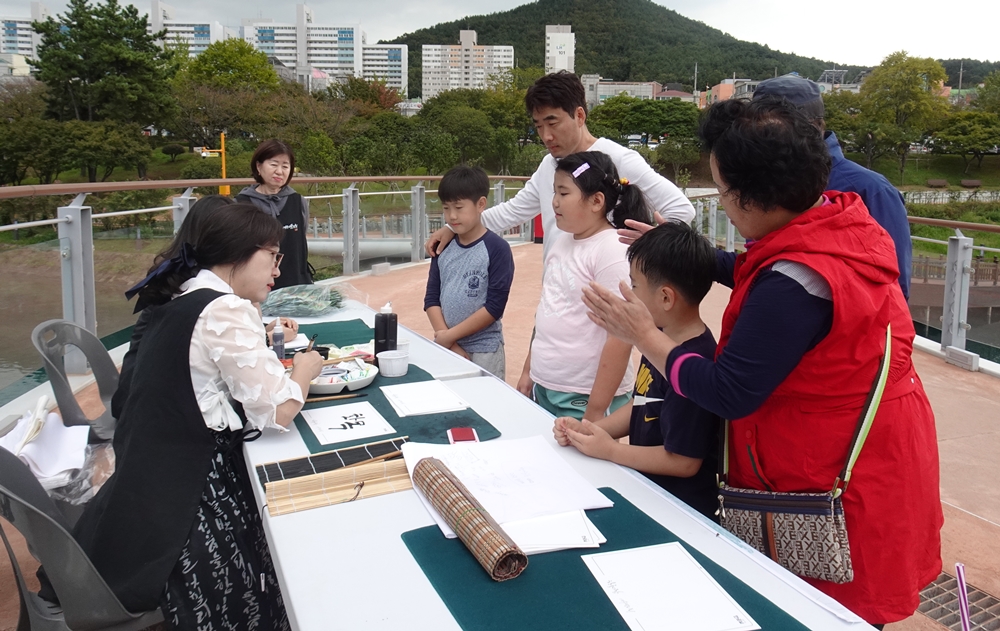 ▲ 황진아 회장이 한 가족의 가훈 '화목'을 캘리그라피로 작성하고 있다.