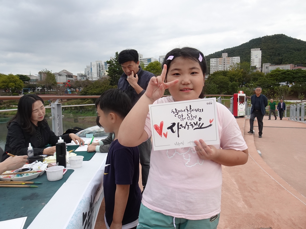 ▲ 요청한 캘리그라피 작품을 받은 아이가 포즈를 취하고 있다.