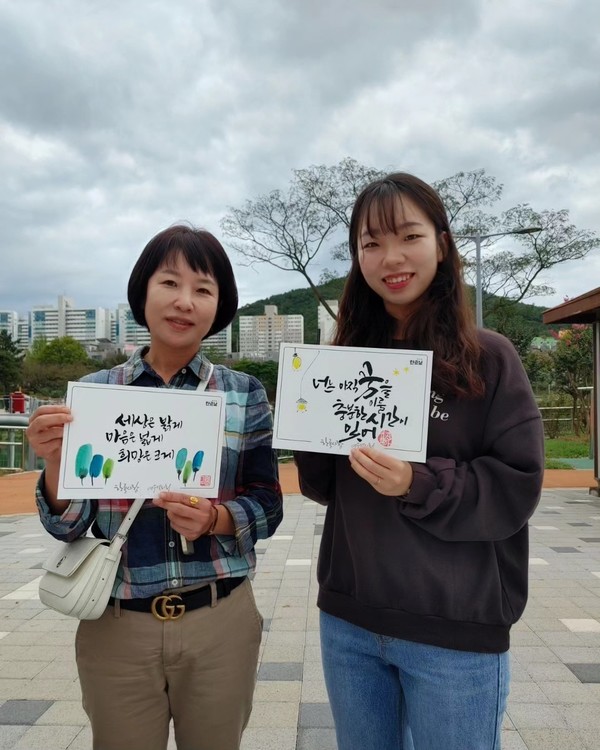 ▲ 가훈을 쓴후 활짝웃는 모녀의 모습