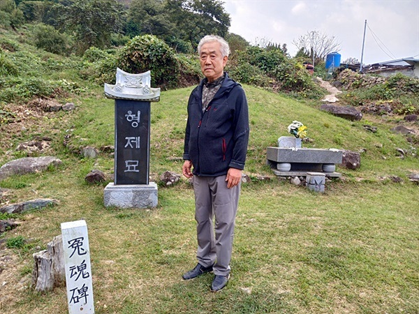 ▲여순사건 당시 큰아버지와 아버지가 묻힌 형제묘 앞에선 박의철씨. 이곳은 여순사건 당시 부역혐의자로 지목된 125명이 1949년 1월 13일 총살당한 후 불태워져 묻힌 곳이다. 박의철씨의 셋째 작은 아버지는 형제묘가 보이는 애기섬에서 학살당해 수장됐다. ⓒ 오문수