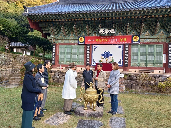 ▲ 템플스테이에 참석한 이들에게 뒤에 보이는 극락전에 대해 설명하는 현장스님. 대원사는 여순사건 때 불탔지만 극락전은 살아남았다.ⓒ 오문수