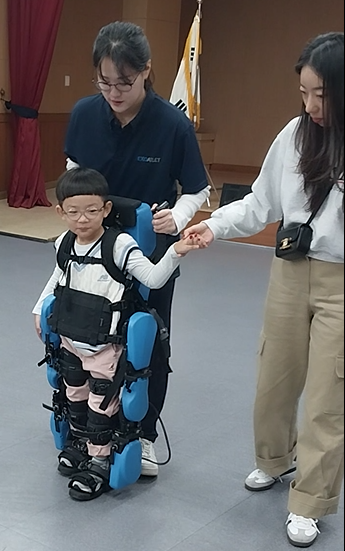 ▲ 뇌성마비로 정상보행패턴으로 보행이 어려운 아동이 로봇을 활용하여 걷는 방법을 배우고 있다.