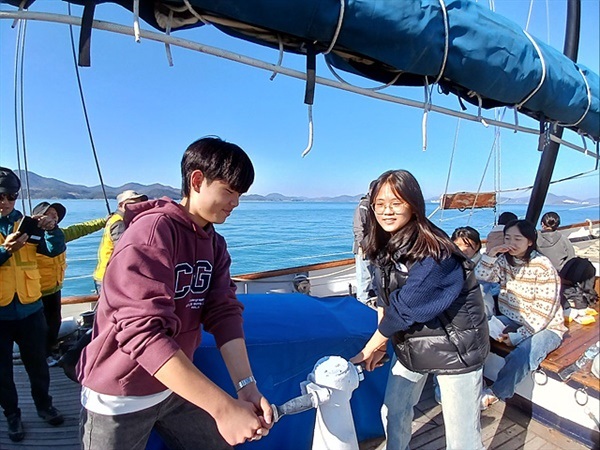 ▲범선인 코리아나호에 돛펴기 실습 중인 학생대표들. 여학생인 김채린(2반 반장)과 고예준(6반 반장)이 협동을 해야 돛을 펼칠 수 있다.ⓒ 오문수