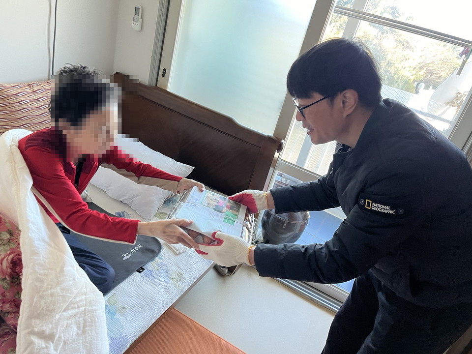 ▲쌍봉복지관 직원이 어르신에게 달걀을 전달하고 있다. ⓒ쌍봉복지관