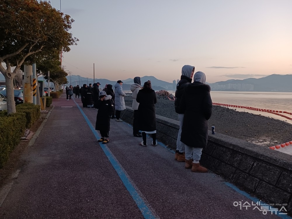 ▲소호동 바닷가에서 일출을 바라보는 사람들 ⓒ전시은