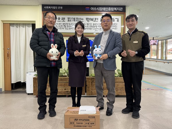 ▲김태영(가장 왼쪽), 김성복(오른쪽 두번째) 후원자가 띠 저금통에 모은 후원금을 여수시장애인종합복지관에 전달하고 있다.