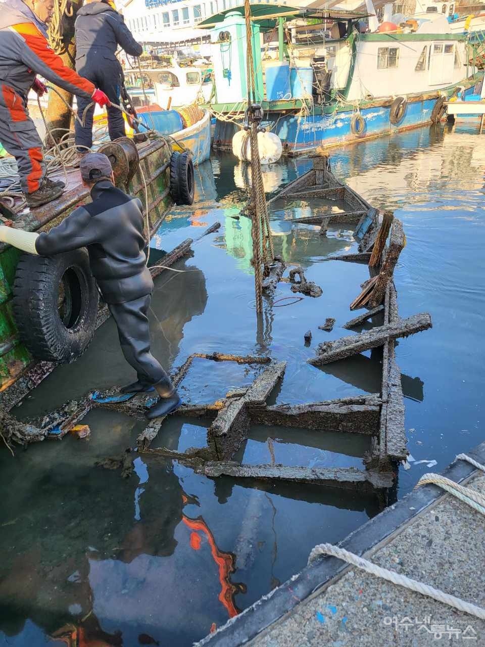 ▲해양폐기물 수거선 크레인이 폐바지선을 들어 올리고 있다. ⓒ수로자원 제공