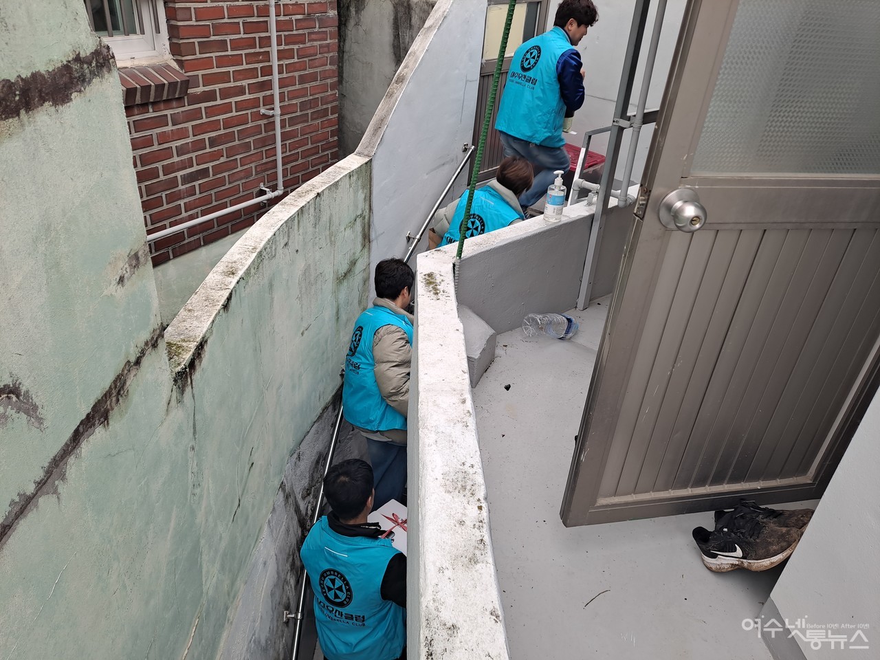 ▲여수 우산클럽 회원들이 위문품을 들고 덕충동 화재 피해 가정 2층 계단을 오르고 있다.  ⓒ조찬현