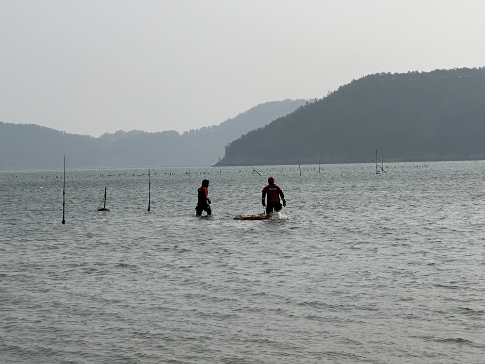 ▲ 해경 구조대원들이 구조보드를 들고 실종자 수색을 위해 바다로 들어가고 있다.