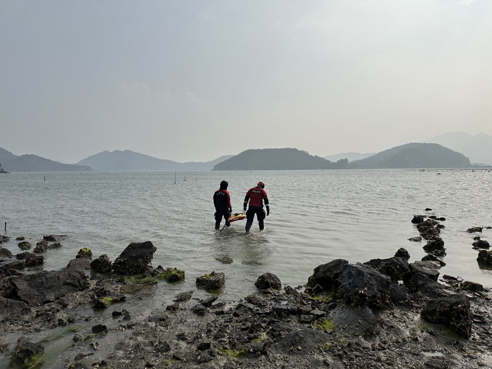 ▲ 해경 구조대원들이 구조보드를 들고 실종자 수색을 위해 갯벌로 들어가고 있다(