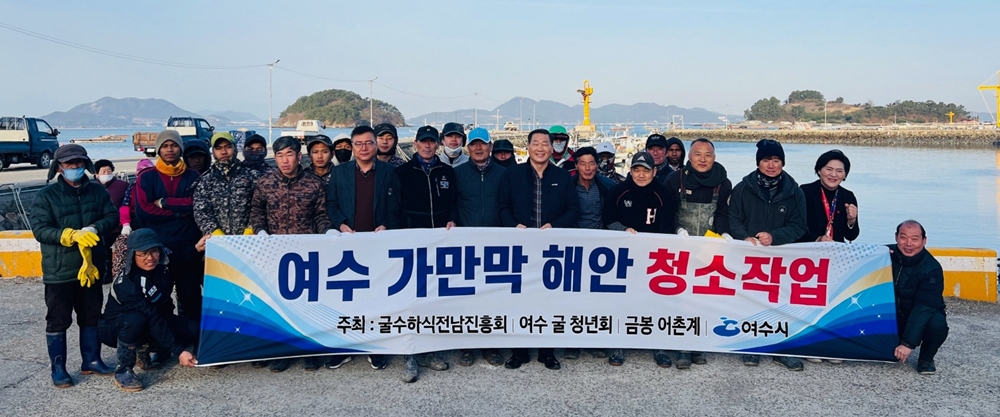 ▲ 가막만 해안청소에 나선 어민들이 단체사진을 찍고 있다.