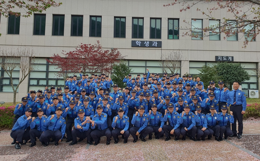 ▲ 예비 해양경찰관과 기수별 학생이  애기동백나무를  심은 뒤 단체사진을 찍고 있다.