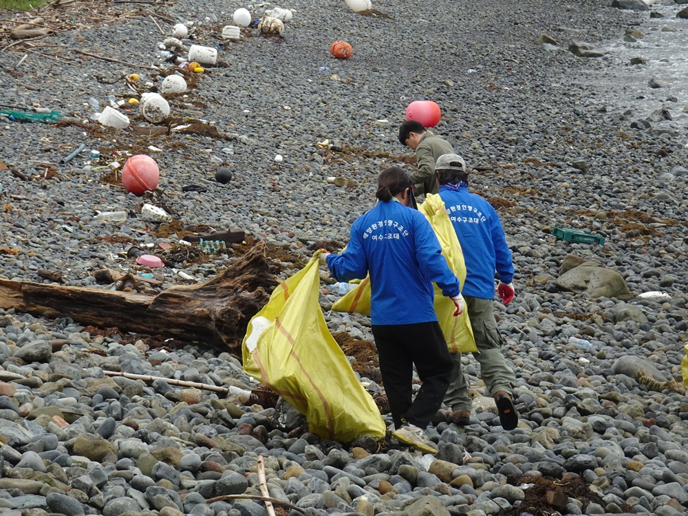 ▲ 해변가에 밀려온 쓰레기를 수거하고 있다. 