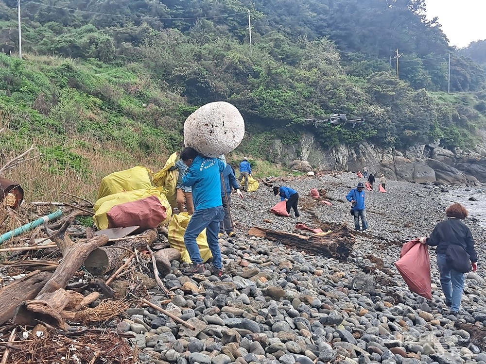 ▲안도 동고지마을 해안가에서 쓰레기를 줍고 옮기고 있는 자원봉사자들이다.  ⓒ조찬현