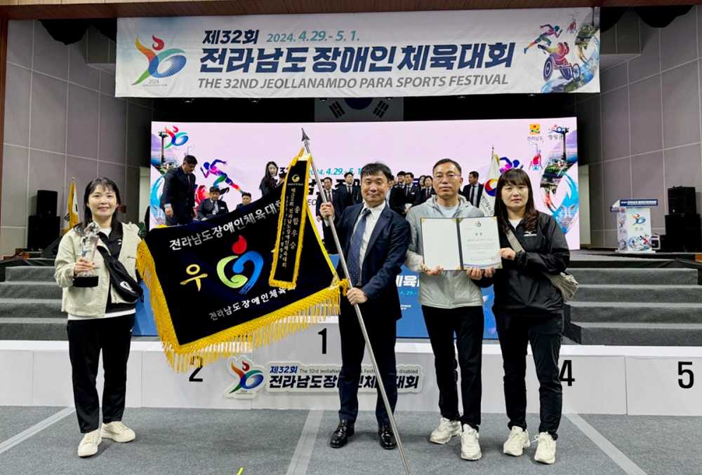 ▲ 여수시장애인체육회 강우연 상임부회장(왼쪽에서 두 번째)이 우승기를 들고 있다.  