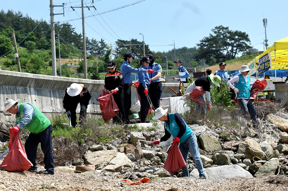 ▲ 7개 민관산학 봉사대원들이 여수시 화양면 감도마을에서 해안가 환경정화활동을 펼치고 있다.