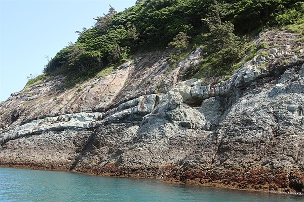 ▲ 지렁이가 기어가는 듯한 모습의 암맥 모습. 암맥과 주변 암석에는 틈이 있고 암석의 성질이 달라서 강한 파도가 치면 쉽게 부서지는 곳이라 암석이 떨어져 나가며 해식동굴이 생긴다.ⓒ 오문수
