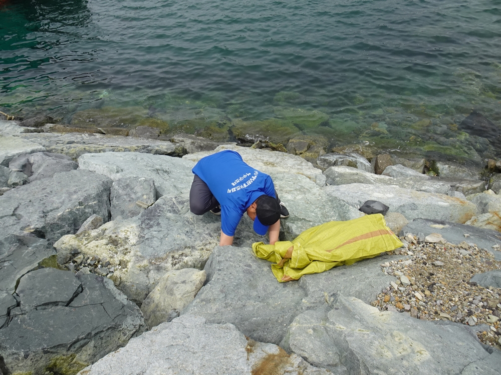 ▲ 바위 사이에 낀 쓰레기를 수거하고 있다.