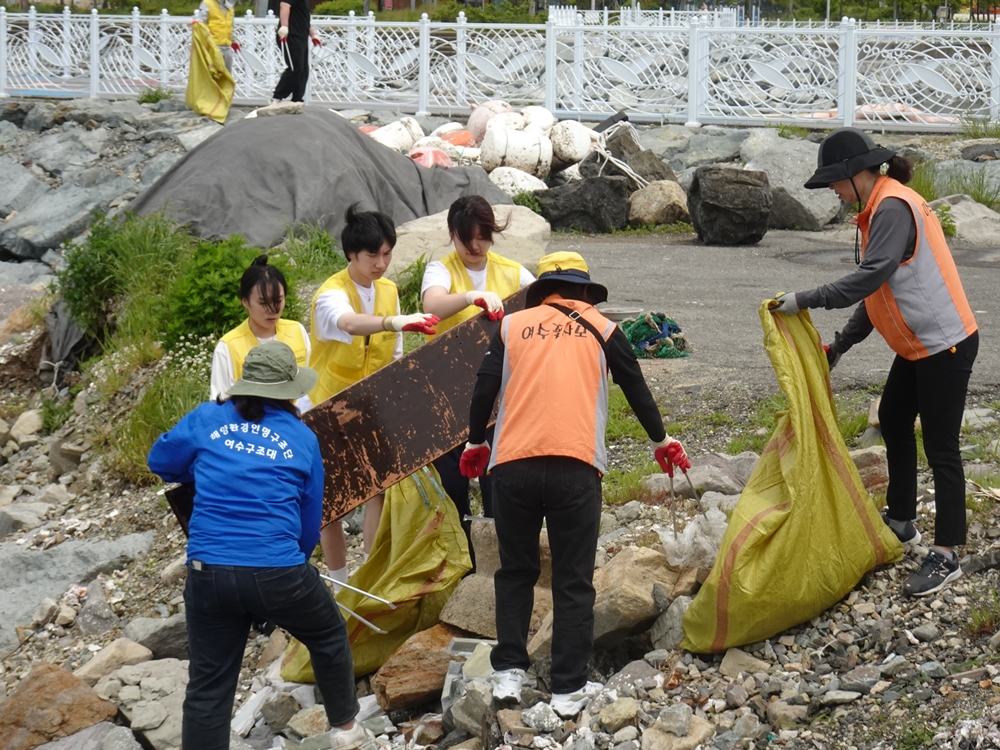 ▲ 봉사자가 함께 쓰레기를 옮기고 있다.