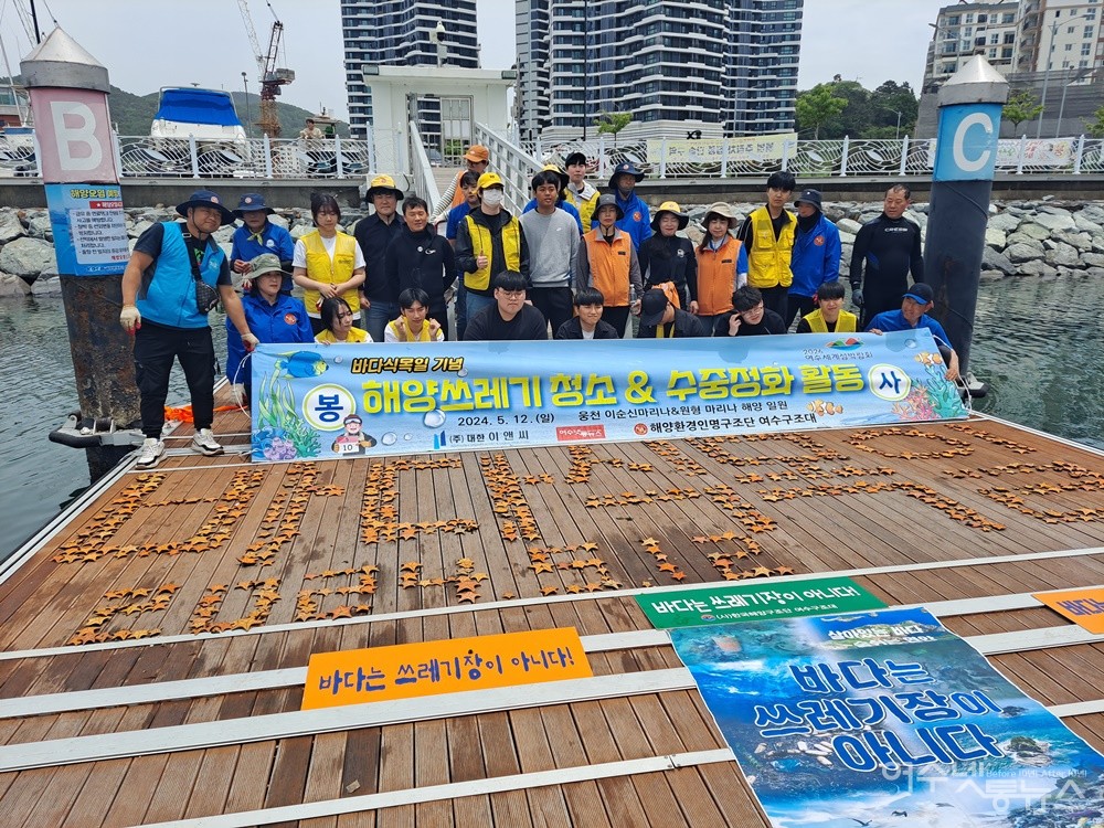 ▲이순신마리나 일원 바닷속에서 수거한 불가사리를 이용해 ‘바다 식목일’ 글씨 퍼포먼스를 펼친 후 함께 기념 촬영을 했다.  ⓒ조찬현