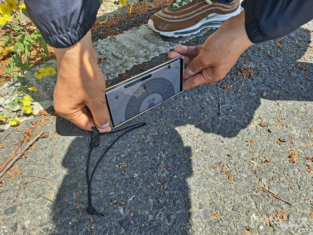 ▲여수세무서 진입로를 오르다 급경사로 인해 전동휠체어의 시동이 갑자기 꺼졌다. 경사를 측정해보니 11.6도(법정 경사각도 4.8도)다.  ⓒ조찬현