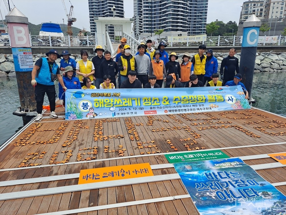 ▲이순신마리나 일원 바닷속에서 수거한 불가사리를 이용해 ‘바다 식목일’ 글씨 퍼포먼스를 펼친 후 함께 기념 촬영을 했다. ⓒ조찬현