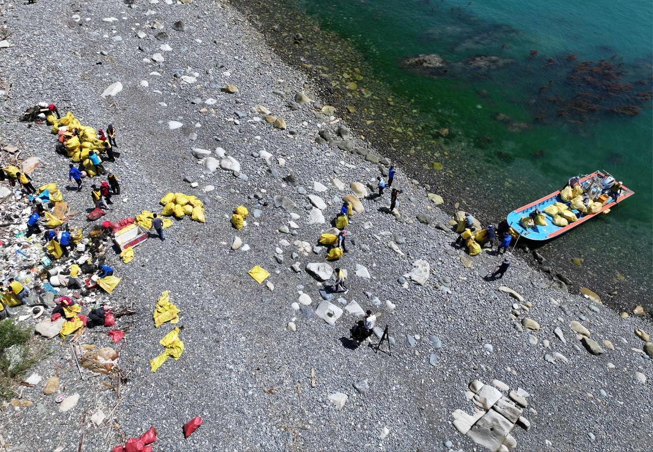 ▲ 봉사단이 해변에 널브러진 쓰레기를 수거하고 있다. ⓒ박근호