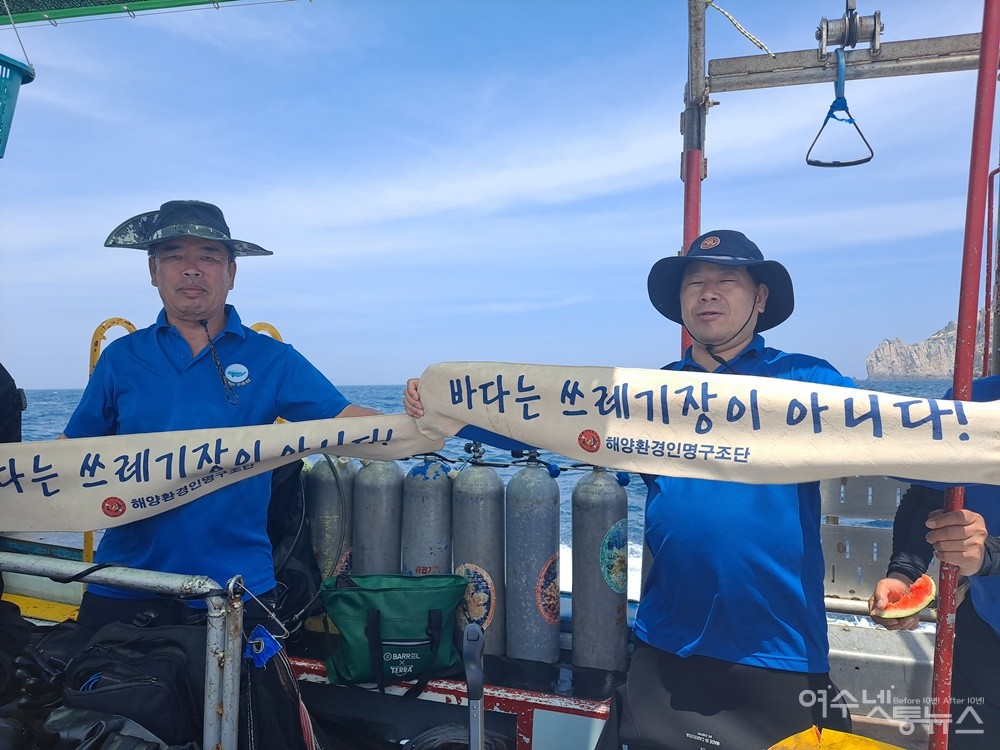 ▲해양환경인명구조단 여수구조대 대원과 대장이 ‘바다는 쓰레기장이 아니다!‘ 현수막을 들고 캠페인을 벌이고 있다. ⓒ조찬현
