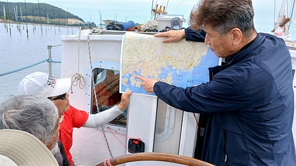 ▲  율리안나호가 노력도 인근 김양식장 뻘밭에 얹혀 3시간 40분 동안 꼼짝할 수 없게 되자 동아지도 대표 안동립씨가 방위각과 지도보는 법에 대해 설명하고 있다. ⓒ 오문수