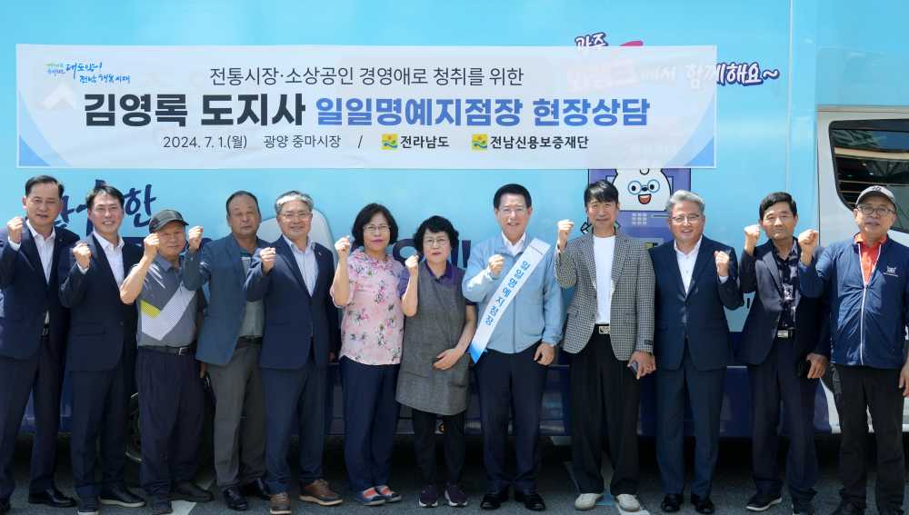 ▲ ‘금융버스 가드림’ 일일명예지점장으로 위촉된 김영록 전라남도지사가 광양 중마시장에서 전통시장·소상공인들과 기념촬영을 하고 있다.