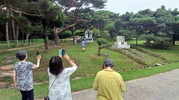 ▲ 제4대 수호원장은 악랄한 간호장 '사또'를 앞세워 환자들을 폭압으로 다스리고 자신의 동상을 세워 매월 20일마다 전 환자들을 동상 앞에 집합시켜 참배시키다 울분을 참지 못한 이춘상에게 살해당했다. 앞에 보이는 이춘상의거 기념비를 둘러보고 사진을 촬영하는 방문단원들. ⓒ 오문수