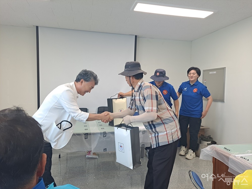 ▲여수중앙병원 박기주 원장이 안도리 손민오 이장에게 의료용품을 전달하고 악수하고 있다.  ⓒ조찬현