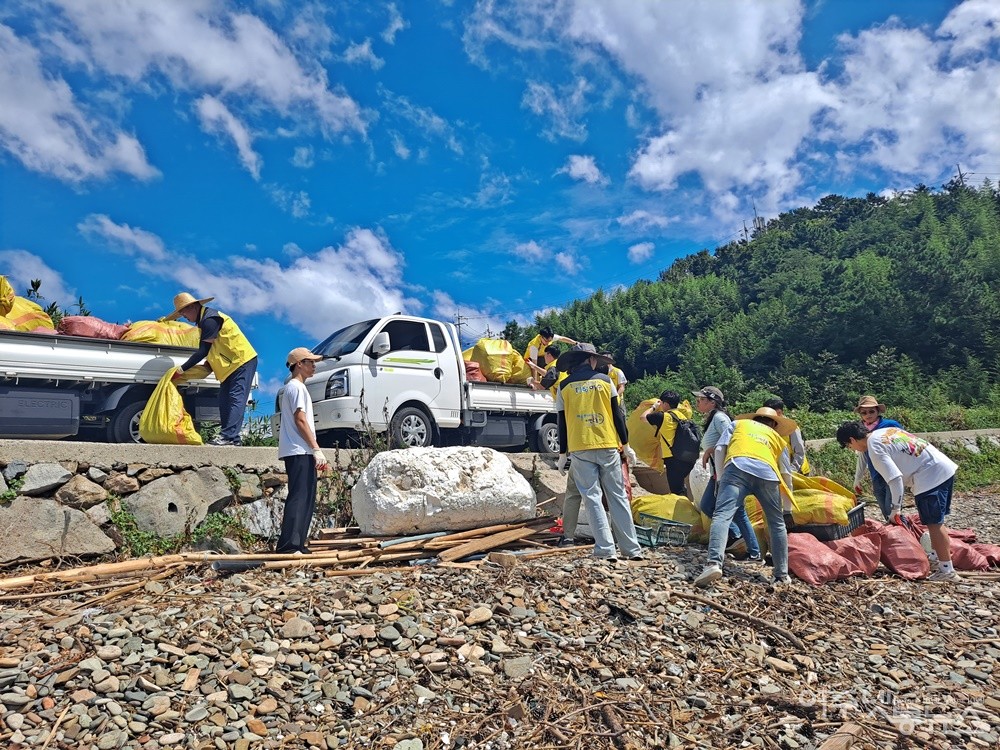 ▲해변에서 주워 모은 쓰레기를 화물차에 싣고 있는 봉사대원들. ⓒ조찬현
