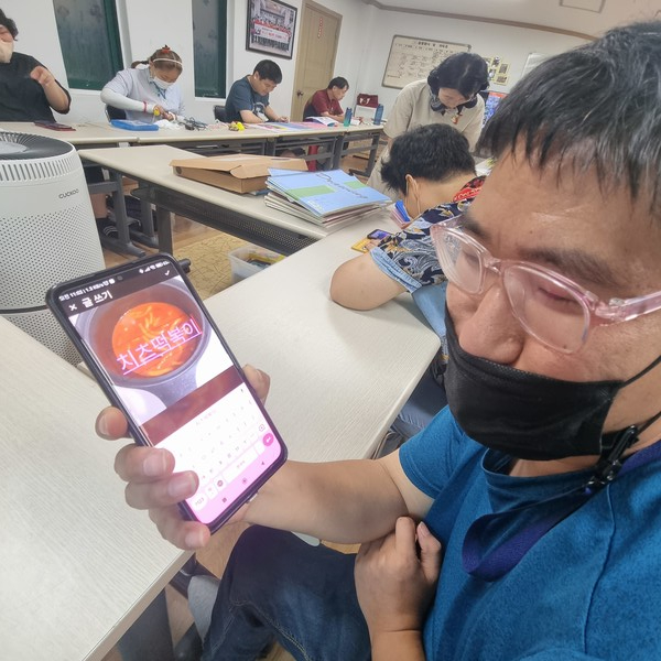 ▲  수업  마침 단계완성을 한  이용인 이*재씨가 기뻐하며 햇터교실선생님께 자랑하고 있다ⓒ 김연우