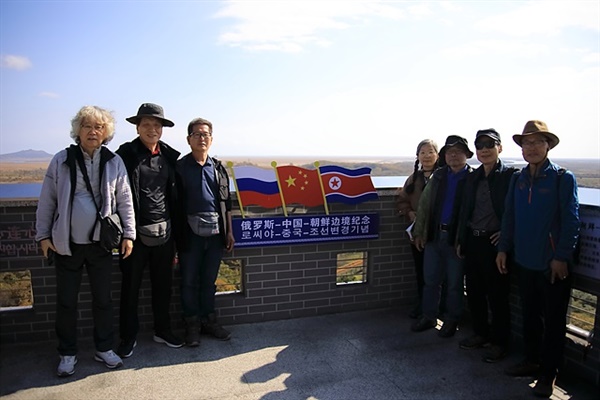 ▲ 조중러 3국 국경이 맞닿은 훈춘 용호각 전망대에서 기념촬영한 일행들. 가운데 3국 국기가 보인다. ⓒ 오문수​