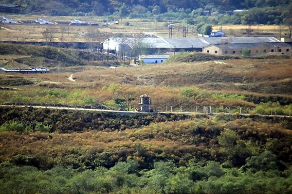 ▲ 훈춘 용호각에서 촬영한 북한측 마을 모습으로 군인감시 초소와 마을이 보인다. 거리가 멀어 망원경으로 살펴보니 "우리식대로 살아나가자!"라는 플래카드가 걸려 있었다 ⓒ 안동립