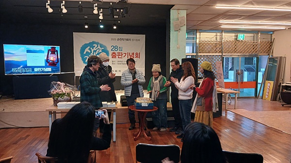 ▲ 김인호 시인의 사진집 출판기념회에서 회원들이 축하케이크를 자르고 있다. ⓒ 오문수