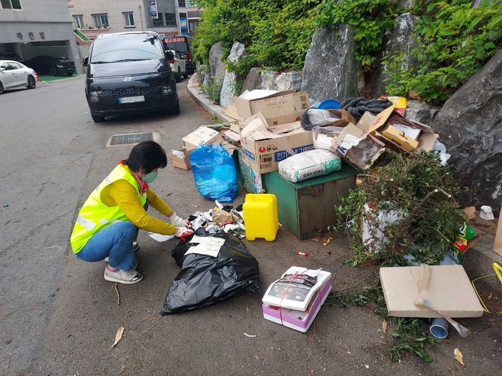 ▲ 불법투기 감시원이 종량제 봉투를 사용하지 않고 배출한 쓰레기를 단속하고 있다.ⓒ여수시